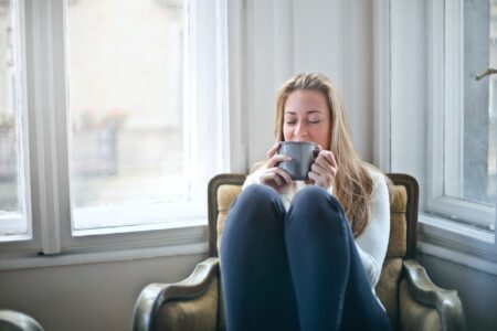 Vrouw-ontstpannen-kopje-thee-op-stoel
